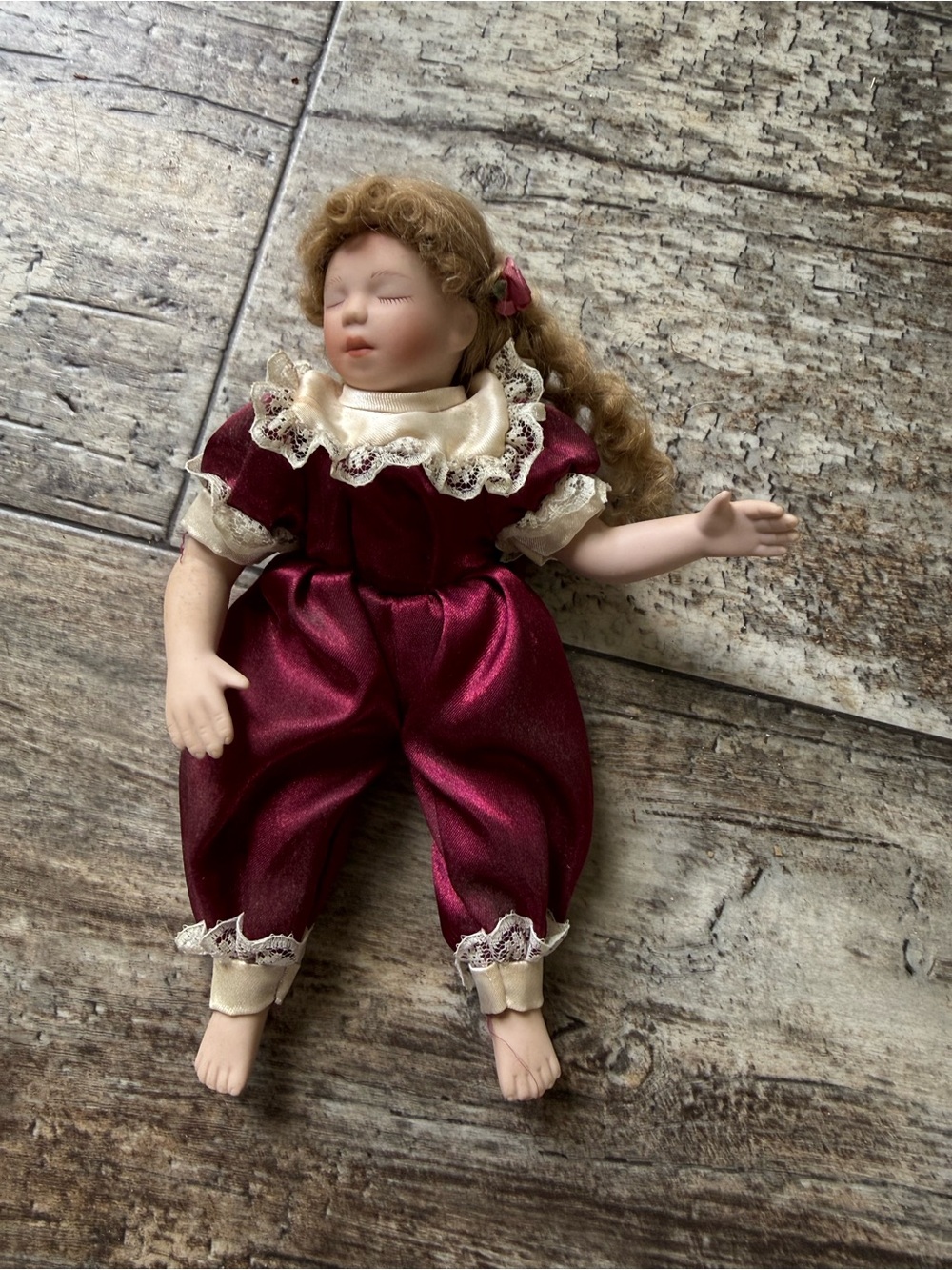 Kathy Hippensteel porcelain sleeping doll dressed in a burgundy satin outfit